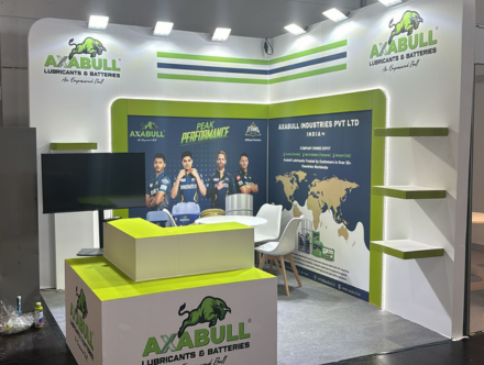 AXBULL booth by Expo Creators with custom white-green design, graphics printing, shelving, and branding for trade expos.