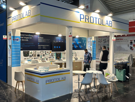 PROTOLAB custom trade show display by Expo Creators with bold blue-white design, professional booth fabrication, and storage setup.